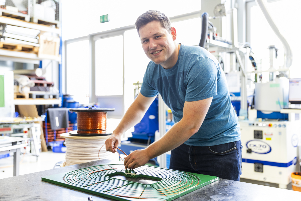 Mitarbeiter Maximilian Heidenreich von Seamless Energy Technologies Gesellschaft mbH in Nürnberg montiert eine der Spulen, mit denen sich Fahrbahnen elektrifizieren lassen.