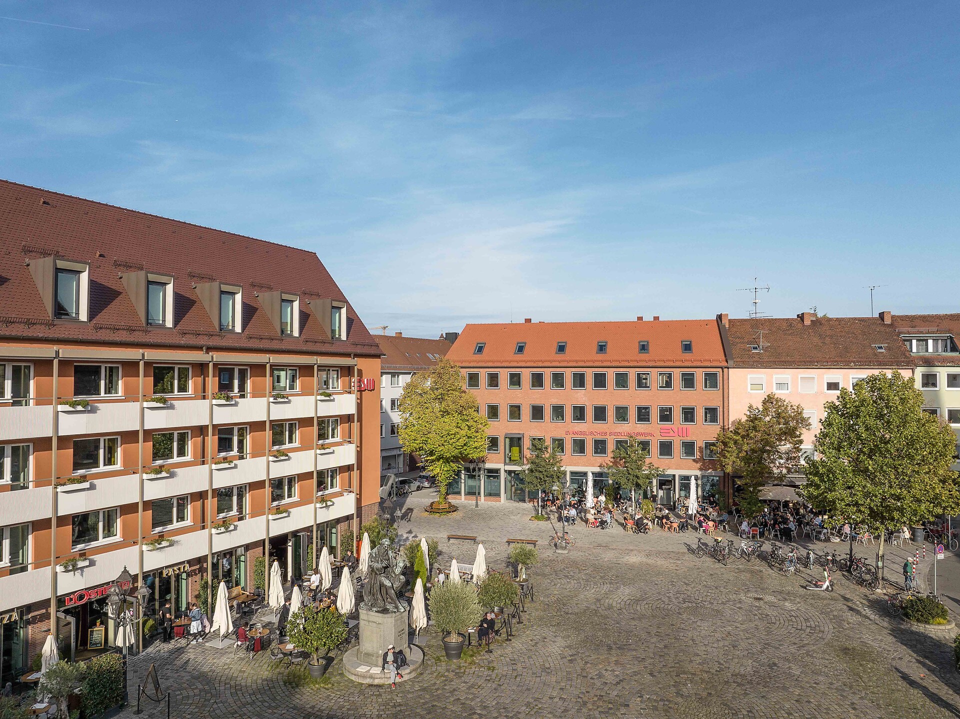 IHK-Immobilienpreis 2025 - Evangelisches Siedlungswerk in Bayern GmbH (Bild 4: Blick auf den Hans-Sachs-Platz): Blick auf den neu gestalteten Hans-Sachs-Platz mit dem sanierten Gebäude des Siedlungswerks. Foto: Christian Höhn Photography